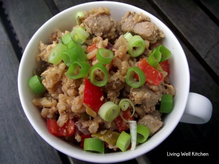 wooden table with bowl of Pork Fried Rice in white bowl topped with green onions 