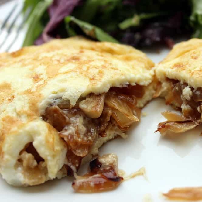 close up look at the inside of a caramelized onions omelette.