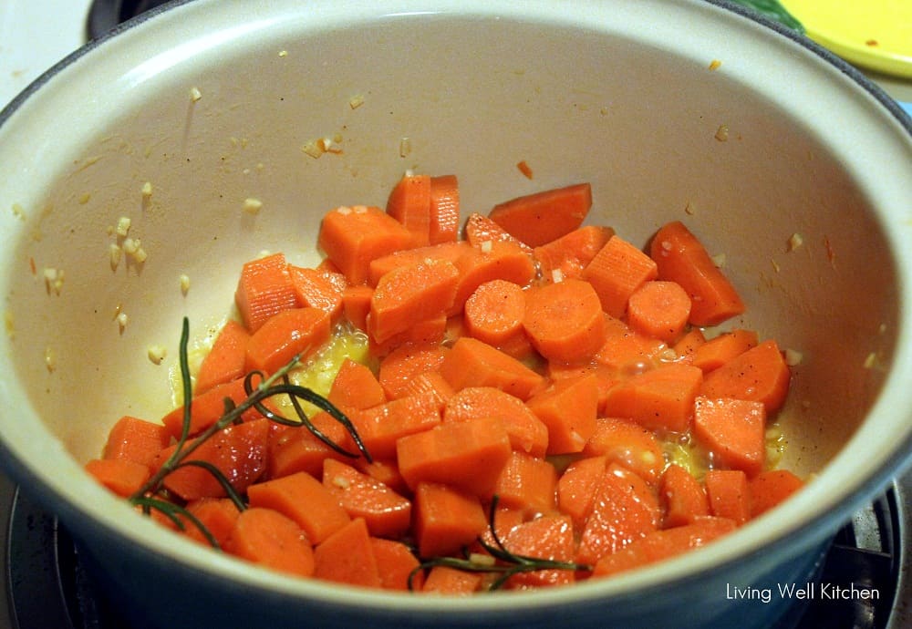 pot with cooked carrots and rosemary on a stove