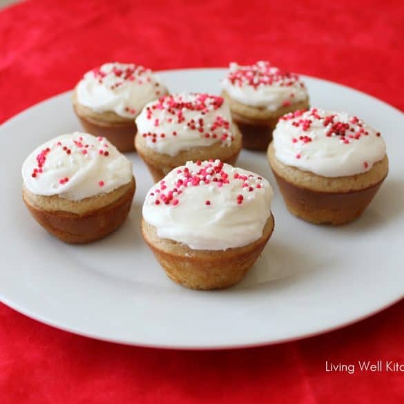 red tablecloth with white plate of small batch vanilla cupcakes sprinkled with pink and red non perils.