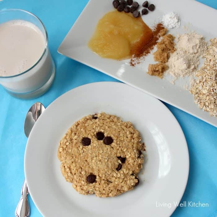 cookie on a white plate on blue table cloth, glass of milk, plate of ingredients