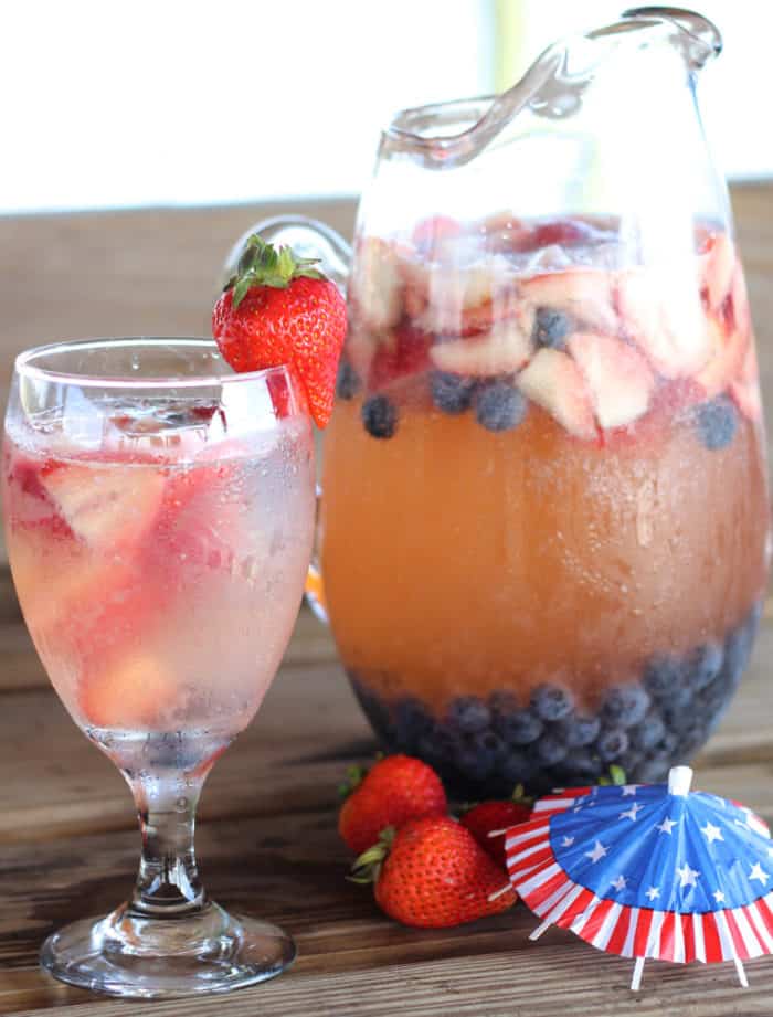 glass and pitcher of Independence Day Sangria with 4th of July drink umbrella