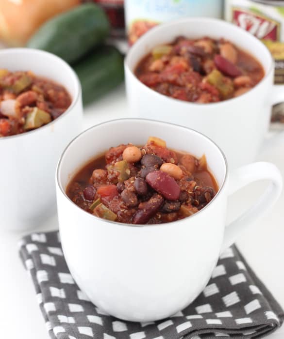 white cups of Three Bean and Quinoa Chili with canned beans in background
