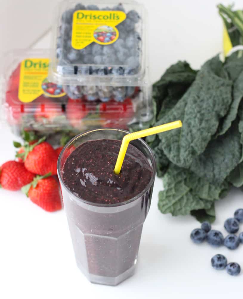 smoothie with yellow straw, blueberries, strawberries and lacinato kale