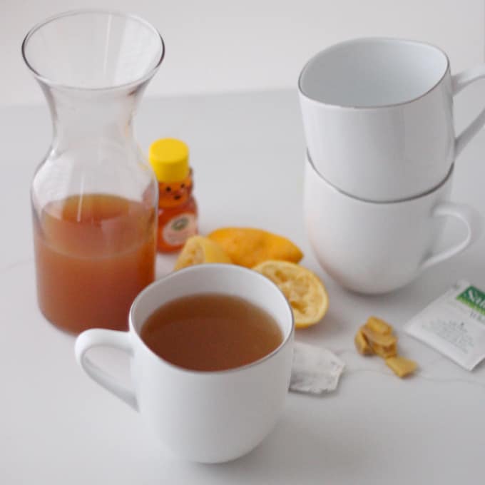 mugs, canister of Ginger White Tea Concentrate, lemon, honey