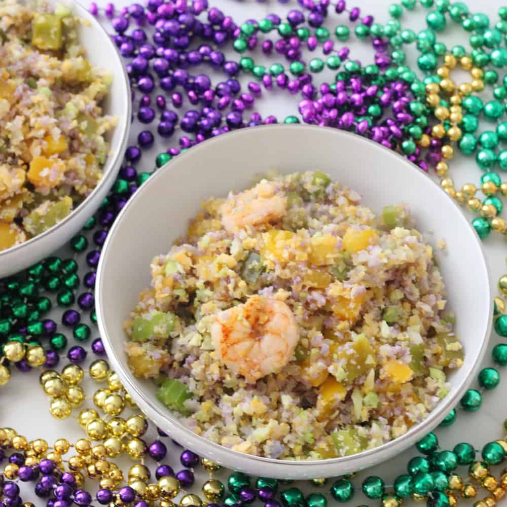 white bowl with Mardi Gras Fried Cauliflower Rice and green, gold and purple beads