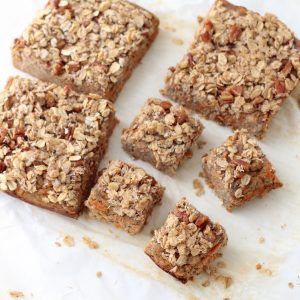 Coconut Carrot Coffee Cake with crumb topping cut into squares on parchment paper
