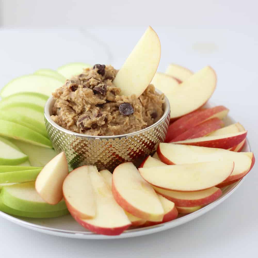 plate of sliced red and green apples with a bowl of Chocolate Chip Cookie Dough Dip