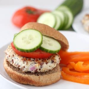 Greek Turkey Quinoa Burgers on a bun with cucumbers and tomato
