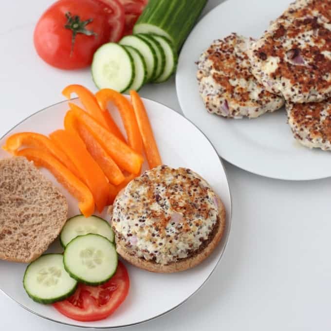 plate of Greek Turkey Quinoa Burgers with burgers, cucumbers, tomatoes, bell peppers