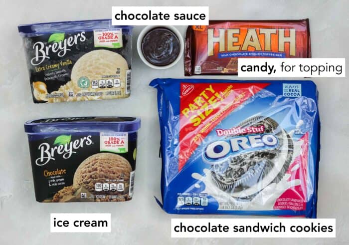 cartons of vanilla and chocolate ice cream, cup of chocolate sauce, a Health chocolate bar, and a package of Oreos