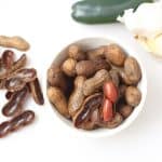 bowl of boiled peanuts with a jalapeno and head of garlic
