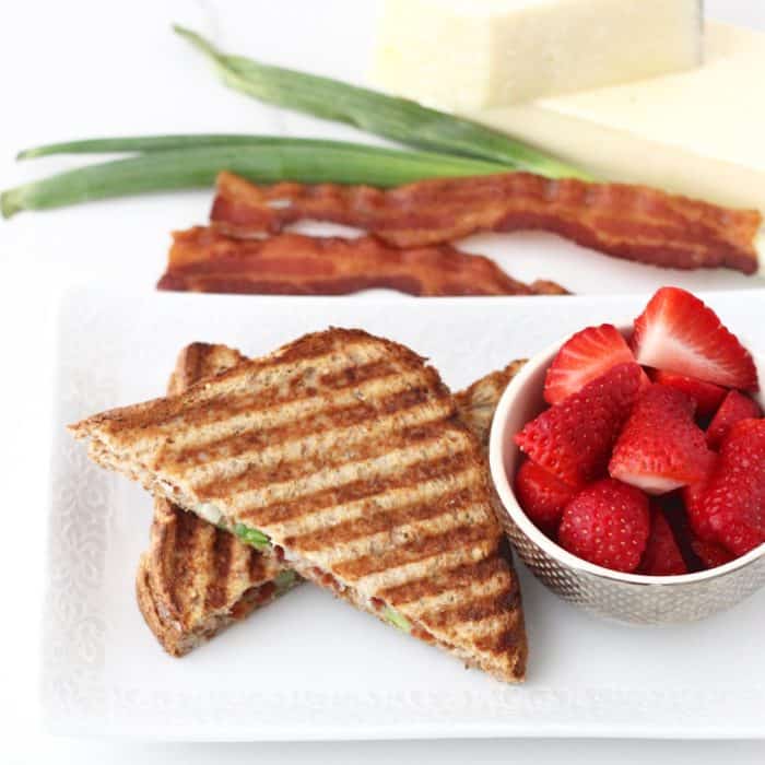 plate of Bacon Grilled Cheese with sliced strawberries, bacon, green onions, cheese