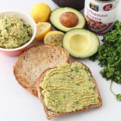 toast with mashed chickpeas and avocado with cut open avocado, can of chickpeas, and cilantro