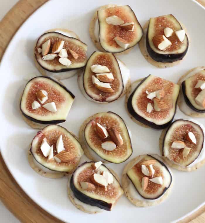 Ricotta and Fig Bites on white plate sitting on wooden cutting board