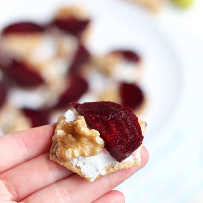 hand holding a Roasted Beet and Goat Cheese Cracker