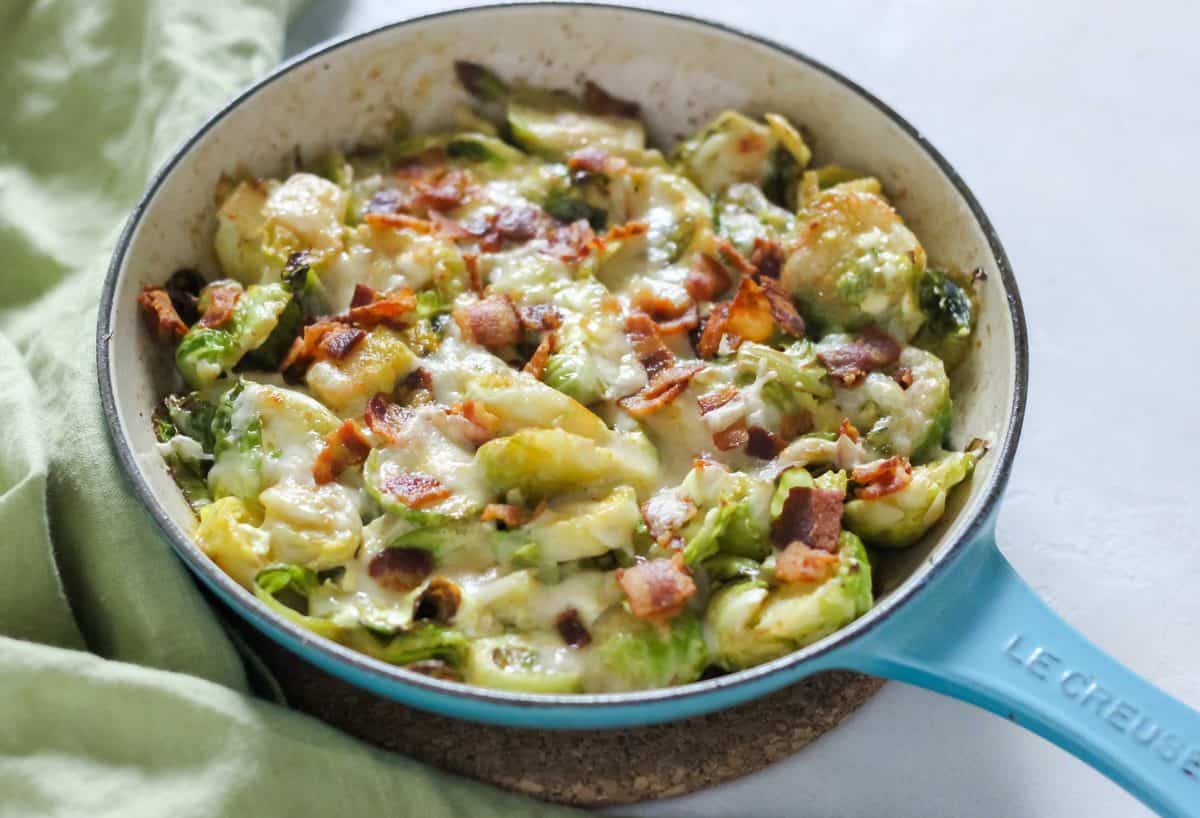 small blue skillet with Brussel sprout dip on green napkin