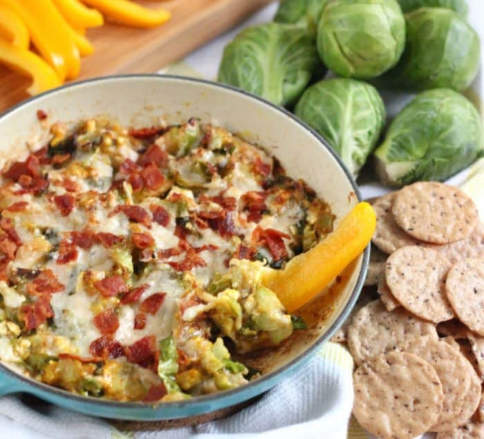 yellow bell pepper dipping into Brussels sprouts dip with crackers, bell peppers, Brussels sprouts 