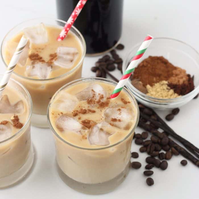 3 glasses of Gingerbread iced Coffee with Christmas straws, coffee beans, vanilla beans, spices