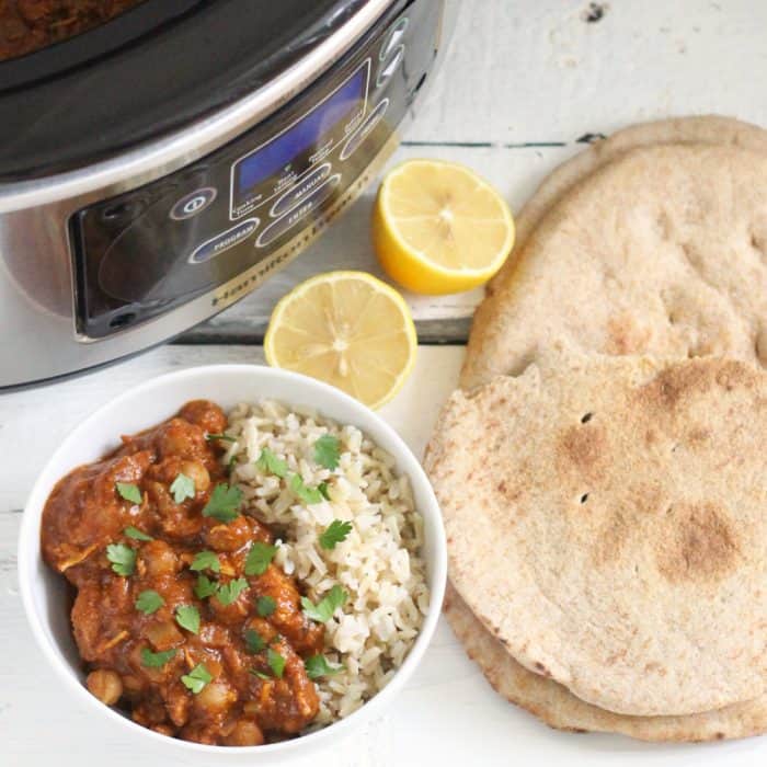 Slow Cooker, lemon halves, naan and a bowl of Chicken Tikka Masala with brown basmati rice