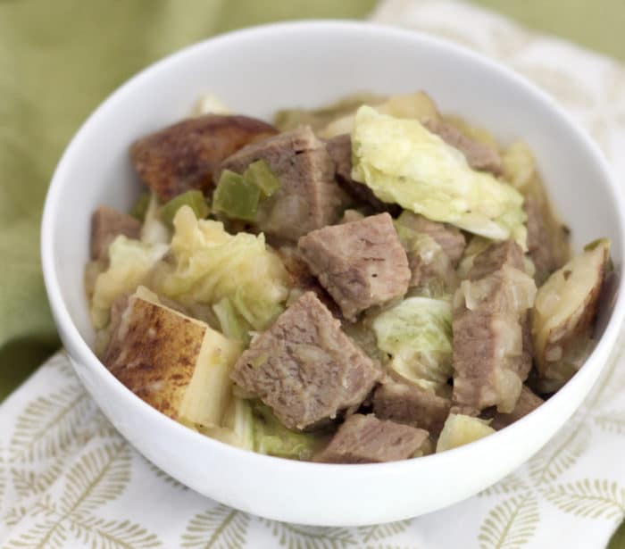 white bowl of Corned Crimson meat and Cabbage Hash on a inexperienced and white napkin