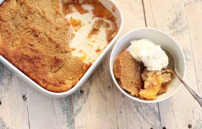 baking dish with peach cobbler and bowl of peach cobbler with ice cream