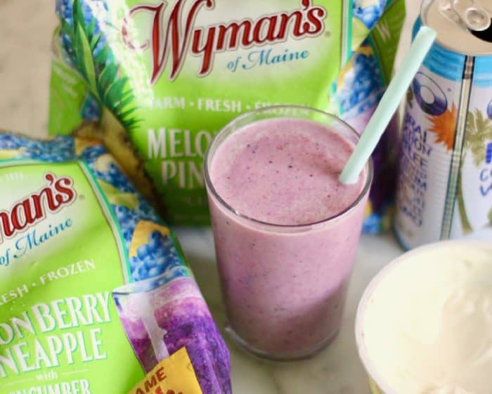 glass of Melon Berry Pineapple with Cucumber Smoothie and blue straw with yogurt, coconut water and frozen fruit bag