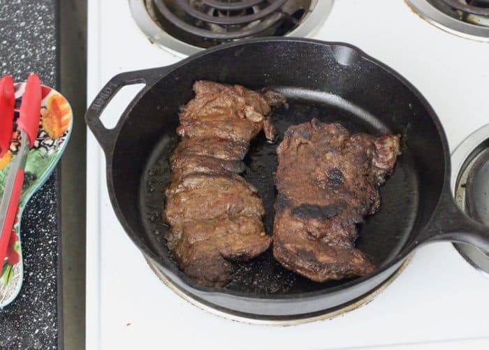 cooking skirt steak in a cast iron skillet
