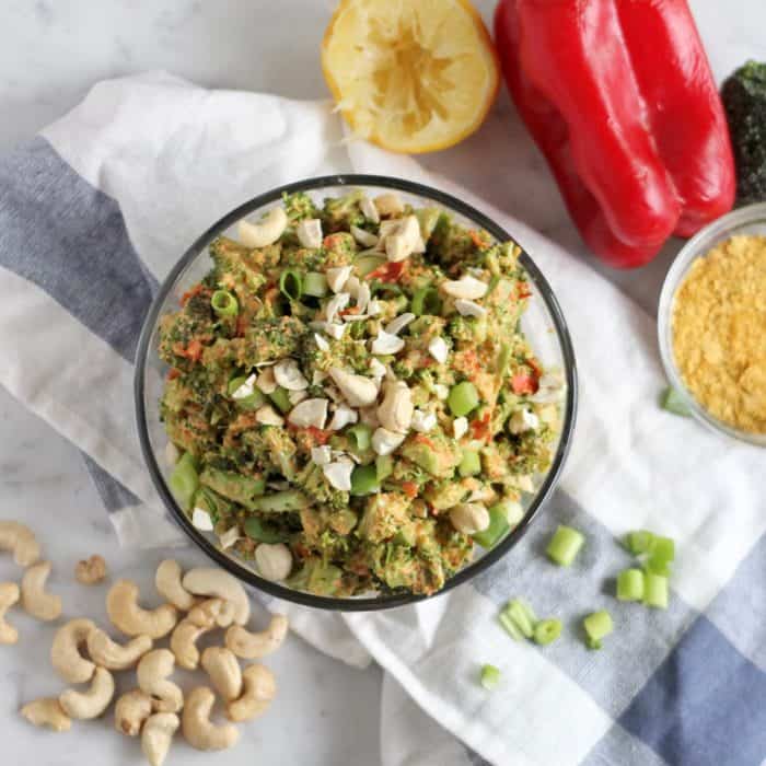 vegan broccoli salad with cashews, green onions, nutritional yeast, red bell pepper, and lemon