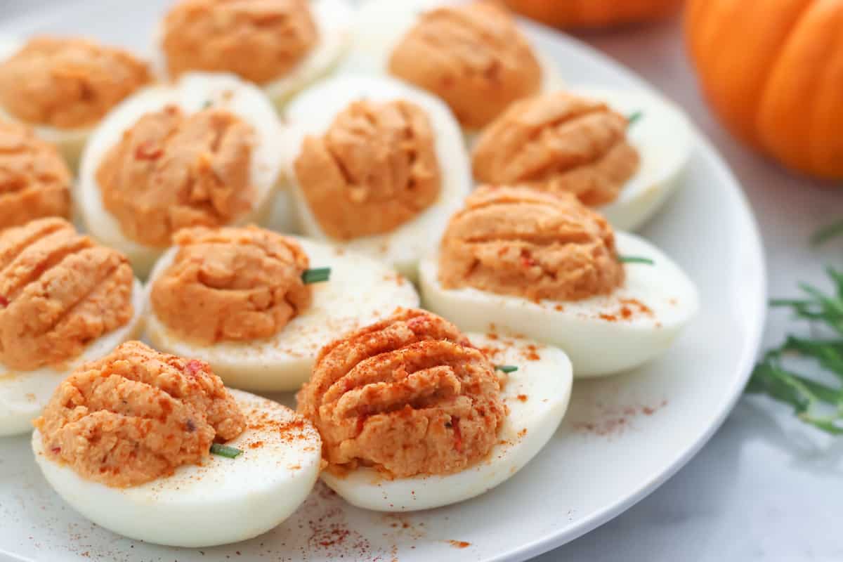 white plate with pumpkin deviled eggs