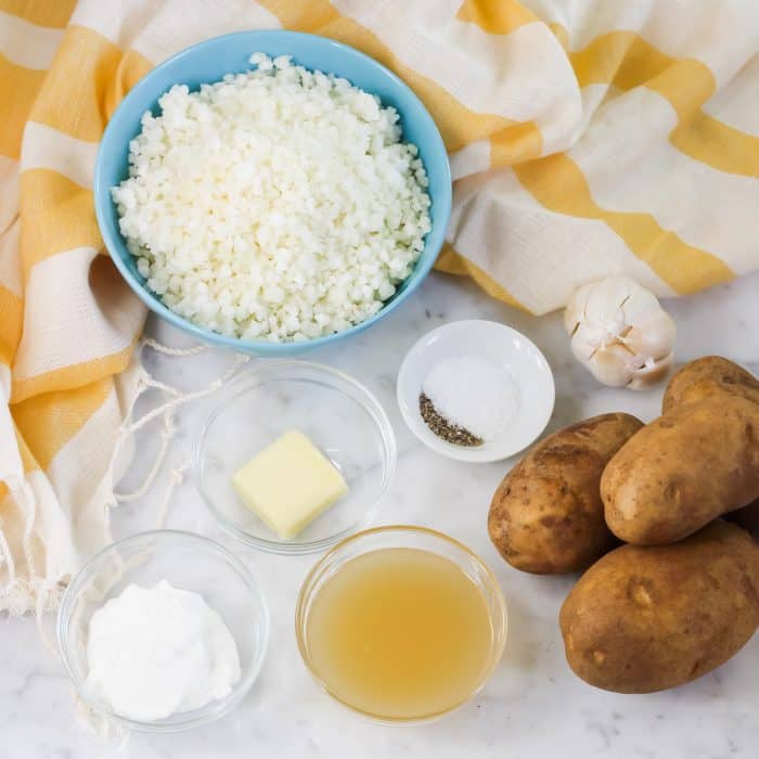 ingredients to make mashed potatoes: cauliflower, potatoes, broth, yogurt, butter, salt, pepper, potatoes