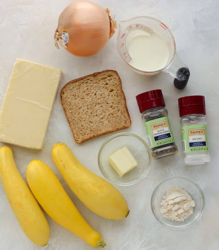 ingredients to make squash casserole: squash, flour, butter, salt, pepper, milk, bread, onion, cheese