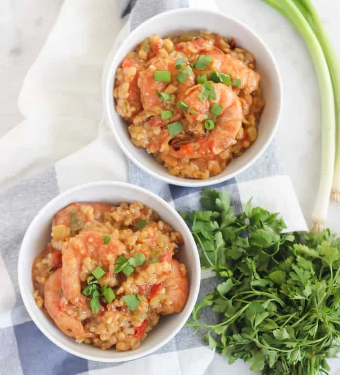 two bowls of jambalaya with green onions, rice, parsley and napkin