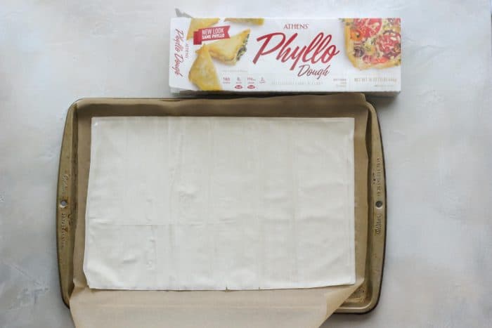 parchment lined baking sheet with phyllo dough and box of dough