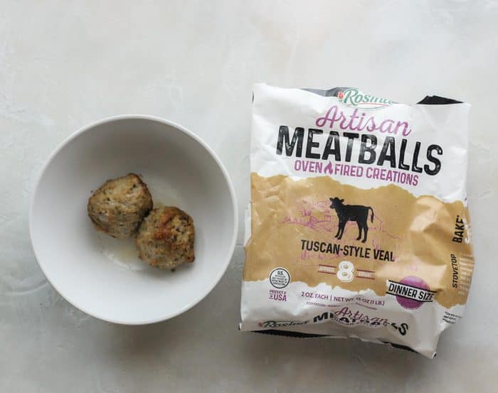 white bowl with microwaved meatballs and bag of frozen meatballs