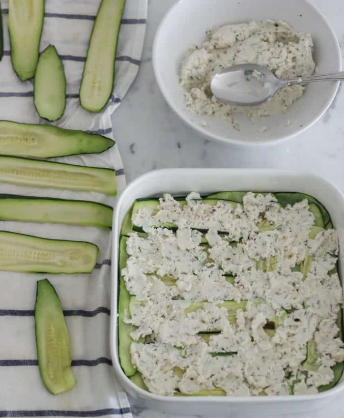 drying cooked zucchini slices on dish towel and layering in casserole dish topped with ricotta