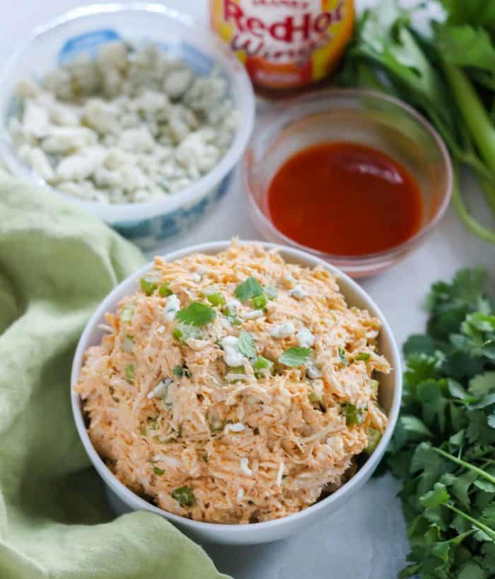 bowls of wing sauce, blue cheese and Buffalo Chicken Salad with cilantro and celery 