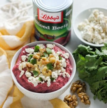 bowl of beet hummus with feta, cilantro, walnuts, and canned beets