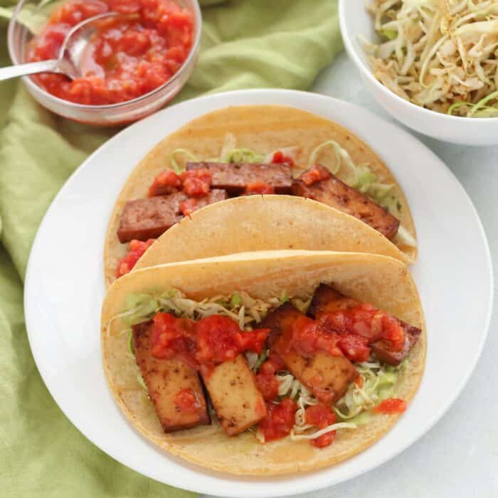 bowl of salsa, slaw, tofu tacos on white plate