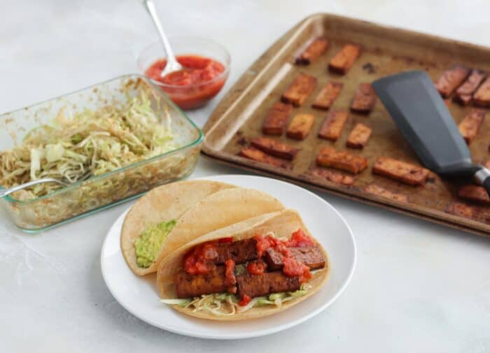 slaw in container, bowl of salsa, tofu on baking sheet, tacos