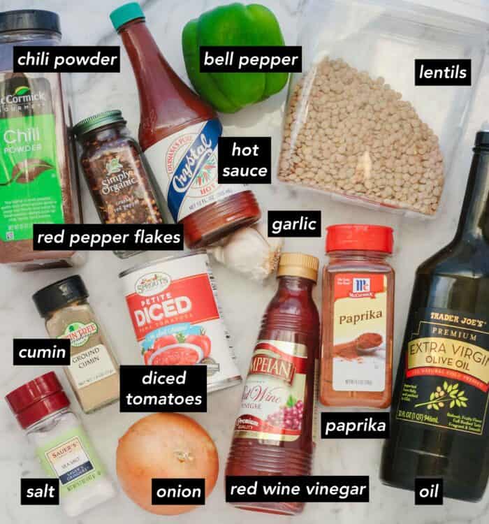 chili powder, red pepper flakes, hot sauce, bell pepper, lentils, garlic, oil, paprika, red wine vinegar, onion, can of diced tomatoes, cumin, salt with text overlay