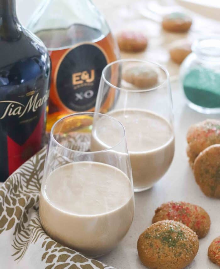 wine glasses with thick drinks, Christmas cookies, green sprinkles, bottles of brandy and tia maria