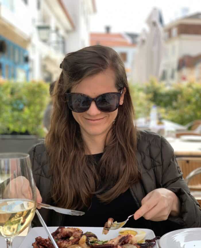 brunette female eating at an outdoor restaurant in Portugal with wine