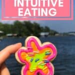 hand holding cookie with text overlay in pink that says self-compassion and intuitive eating