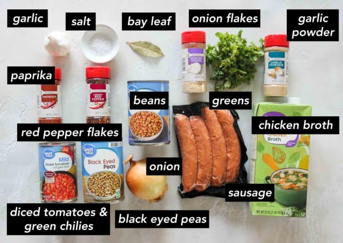 garlic, salt, bay leaf, minced onion, kale, garlic powder, chicken broth, sausage, beans, onion, black eyed peas, diced tomatoes, paprika, crushed red pepper