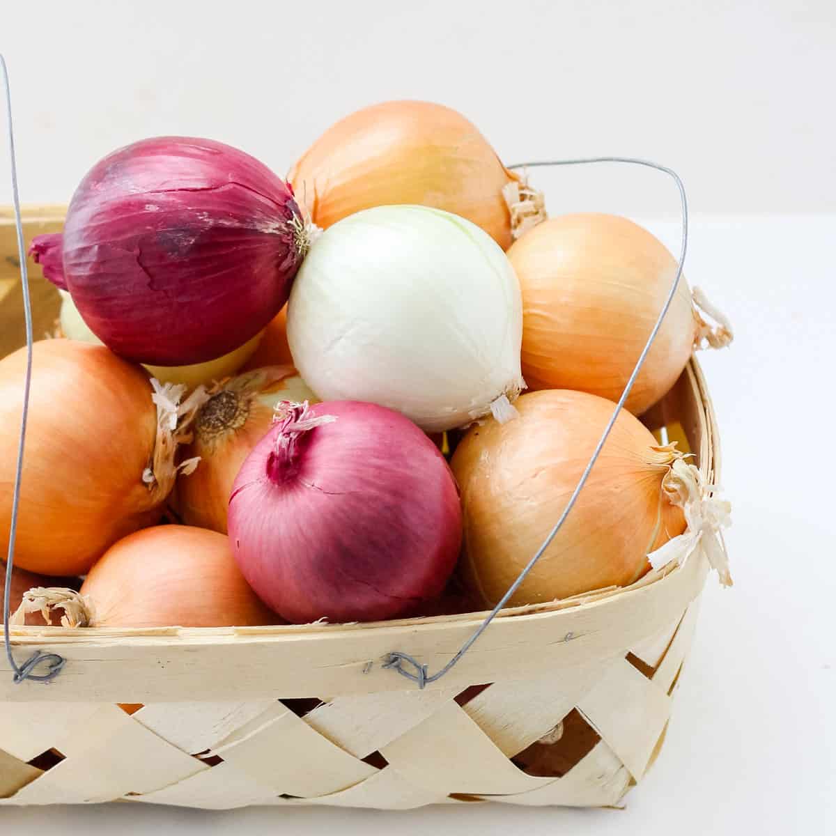 basket with yellow, red, and white onions