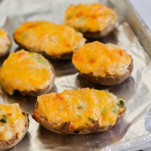 a baking sheet lined with foil with twice baked potatoes after baking