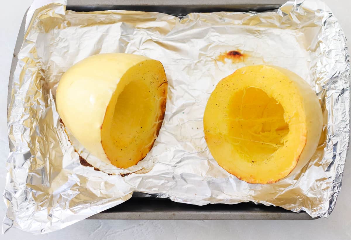 cooked spaghetti squash on a foil lined baking sheet