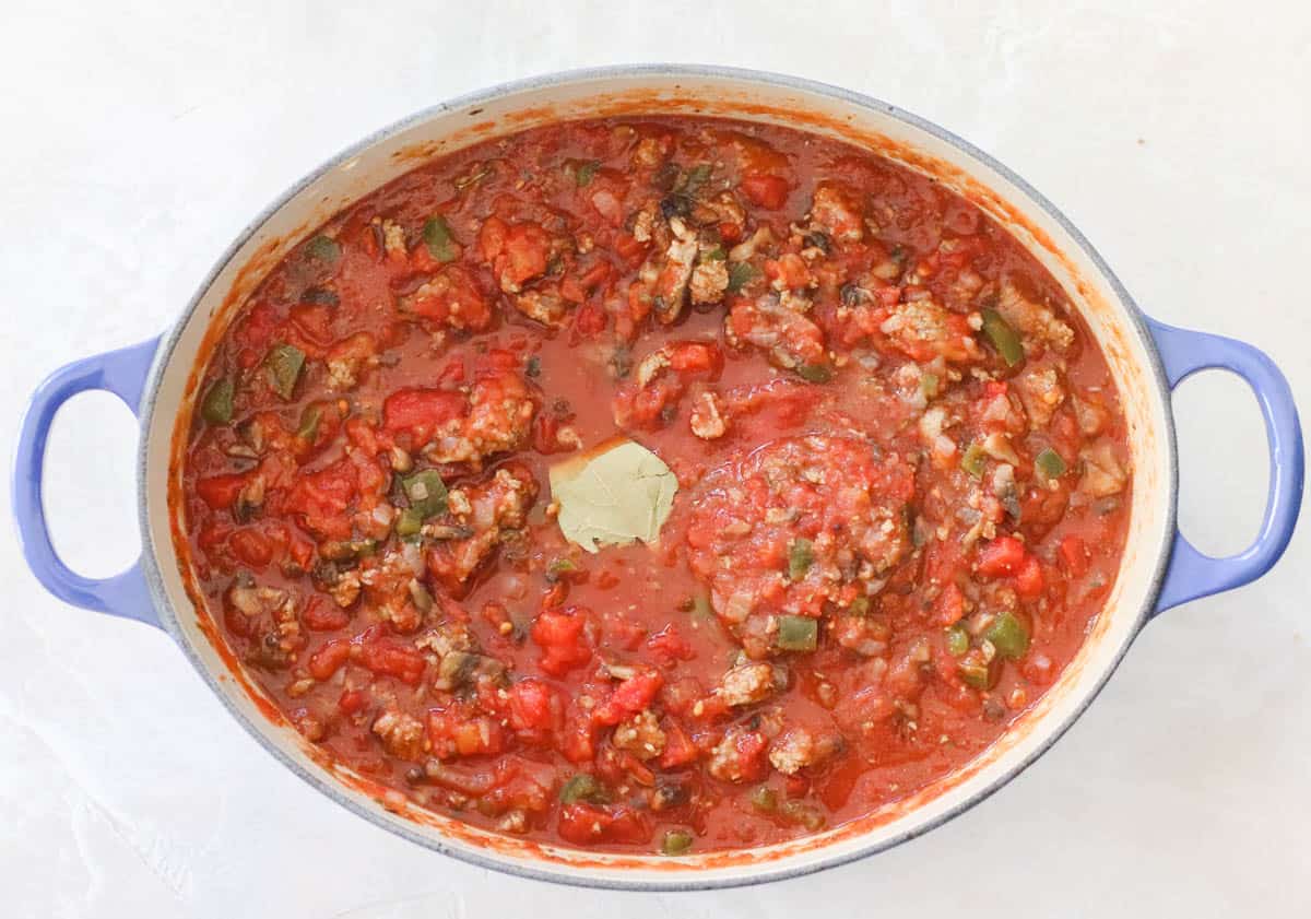 blue pot with cooked turkey red spaghetti sauce and a bay leaf