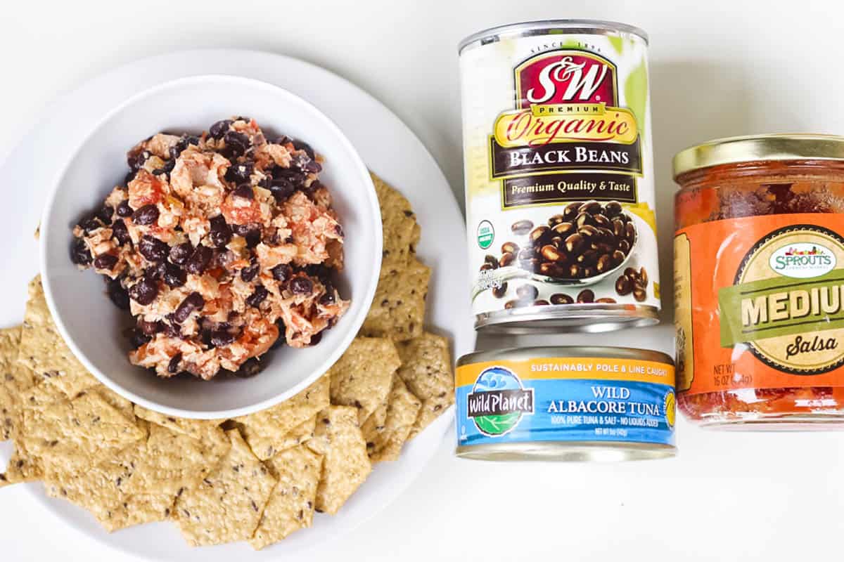 bowl of salsa tuna salad with crackers next to cans of black beans, tuna. and salsa.